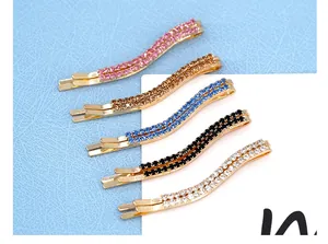 Dettaglio di fermagli per capelli ondulati a doppia fila di strass in cinque colori