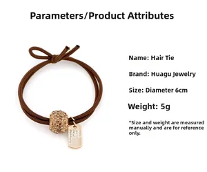 Détail d'élastique cheveux marron avec boule en strass et pendentif en métal