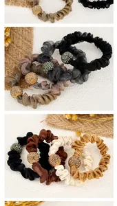 Macro detail of pleated mesh hair scrunchie with rhinestone ball and elastic hair tie