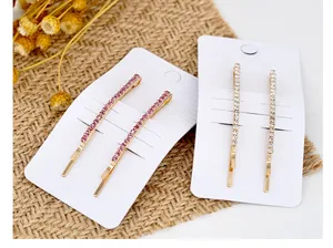 Dettaglio di fermagli per capelli con strass rosa e bianchi su carta da esposizione
