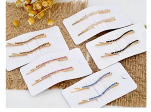 Dettaglio di fermagli per capelli con strass colorati su cartone e sfondo materico