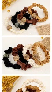 Detail of satin scrunchies in earth tones with sparkling rhinestone golden ball charms