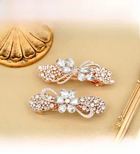 Close-up of rose gold flower hair clips with sparkling white rhinestones on luxury background