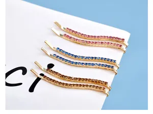 Dettaglio di sei forcine con strass a onda in rosa, blu e ambra su base dorata