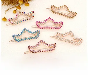 Detail of crown rhinestone hair clips in six colors on a soft pink background