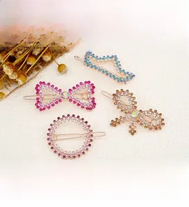 Detailed view of four colorful rhinestone hair clips with bow and geometric designs