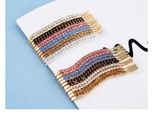 Dettaglio macro di fermagli per capelli con strass scintillanti in varie forme e colori