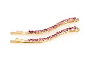 Dettaglio di due fermagli per capelli ondulati con base dorata e strass di cristallo rosa