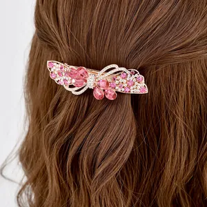 Elegant rose gold butterfly hair clip with pink crystals on wavy brown hair