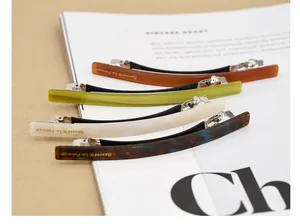 Détail de quatre barrettes à cheveux en acétate ambré, vert, blanc et écaille de tortue