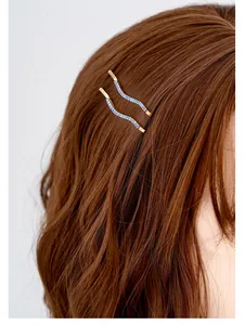 Dettaglio dei fermagli per capelli a onde con cristalli blu su capelli castani