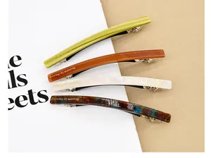 Gros plan de quatre barrettes à cheveux en acétate coloré avec texte Barette la France