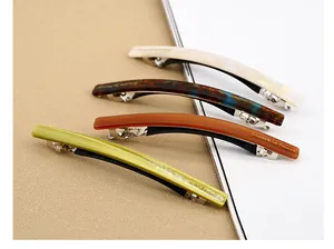 Détail de quatre barrettes en acétate marbré et écaille avec clips à ressort dorés