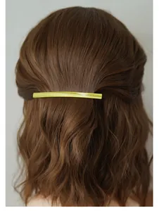 Détail de la barrette en acétate vert néon sur cheveux bruns avec gravure La France