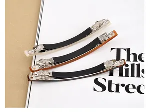 Vue macro de trois barrettes à ressort en acétate en blanc, ambre et écaille foncée