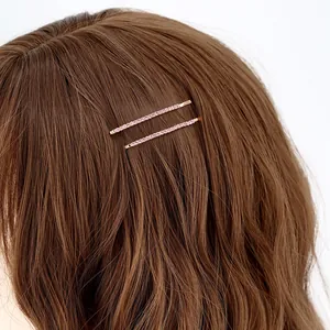 Set di due fermagli per capelli dorati minimalisti con strass rosa su capelli