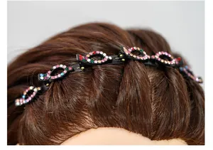 Macro-opname van kleurrijke strassteentjes op zwarte gevlochten haarband met clips