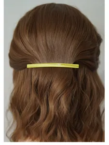 Détail de la barrette en acétate vert citron sur cheveux bruns avec texte La France