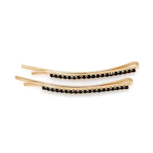 Set di due fermagli per capelli in oro con strass neri su uno sfondo bianco pulito