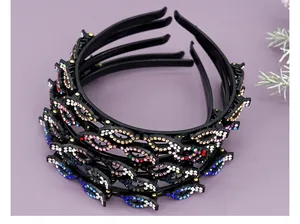 Detail van de dubbellaagse haarband met gekleurde strass en gevlochten haarklemmen