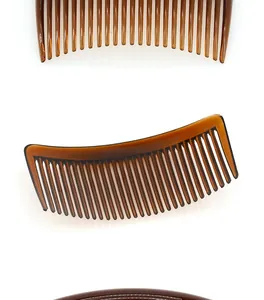 Detailed view of amber plastic side hair combs with curved fine teeth on white background