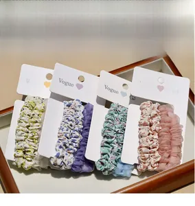 Detailed view of floral and solid scrunchies set on a premium wooden tray display