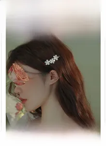Elegant cat eye stone flower hair clip with crystals shown on a model side view