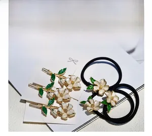 Detail of floral hair accessory set with enamel flower clips and elastic hair ties