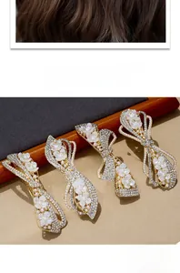 Detail of four golden bow hair clips with white flowers, pearls and rhinestones