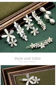 Detail showing floral cat-eye stone hair clips with crystal accents on a textured background