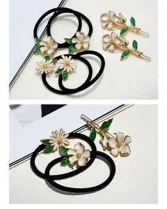 Detail of floral hair accessory set with white enamel petals and gold hair clips