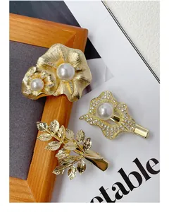 Detailed view of luxury gold hair clips with white pearls and sparkling crystals