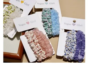 Close-up of floral print cotton and mesh scrunchies on branded display cards