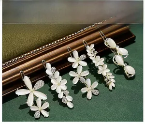 Detailed close-up of 5-piece gold hair clip set with cat eye stones and crystals