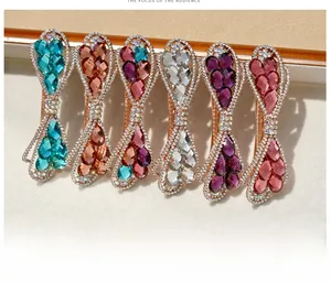 Détail de six barrettes à cheveux en cristal avec base or rose et pierres colorées