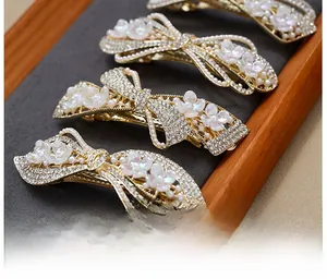 Macro detail of rose gold hair clips with rhinestones and white pearl flowers