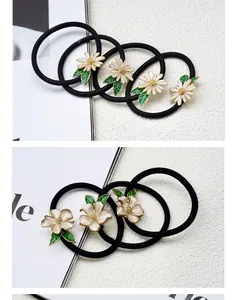 Detailed view of floral hair ties with white daisy and camellia alloy charms