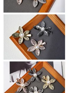Detail of floral hair clips with hammered metal texture and white center pearls