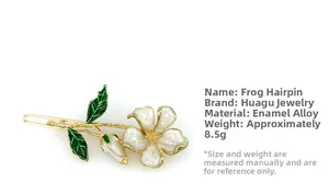 Detail of flower hair clip with white petals and green leaves on golden alloy base