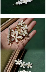 Detail of golden hair clip with cat eye stone flower and sparkling crystal rhinestones