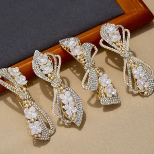 Elegant gold alloy bow hair clips with rhinestones, pearls and white flower details