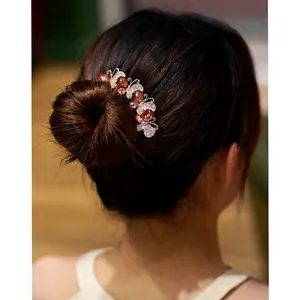 Elegant butterfly hair comb with crystals and rose gold finish worn on a bridal hairstyle