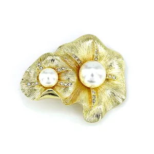 Minimalist gold metal flower brooch with large white pearls and sparkling rhinestone accents