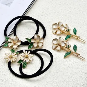 Elegant floral hair accessory set with white flower hair ties and golden hair clips