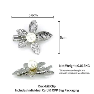 Silver flower hair clip with pearl center and textured petals on a duckbill base