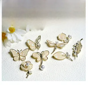 Set of seven gold-tone brooches featuring butterfly, dragonfly, and floral shell motifs