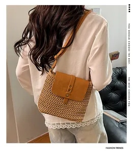 Detail of bohemian woven crossbody bag with brown leather flap and bronze rivets