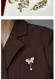Detail of shell butterfly brooch with pearl pendant on a dark brown suit blazer lapel