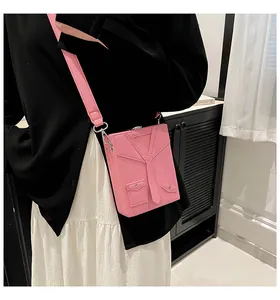 Close-up of pink suit-style crossbody bag with tie detail and lychee leather texture