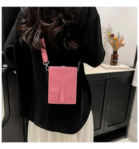 Pink rectangular crossbody bag with creative suit collar design worn on a dark outfit